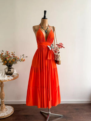 Orange tiered maxi dress with plunging V-neck, cinched waist, and halter straps.