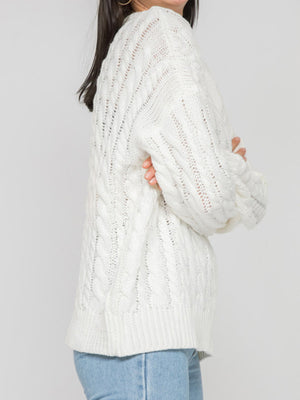 White cable knit openwork sweater with crew neck and long sleeves.