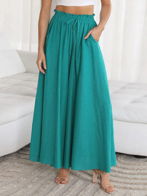 Teal gathered waist palazzo pants with drawstring and pockets, made of 100% polyurethane.