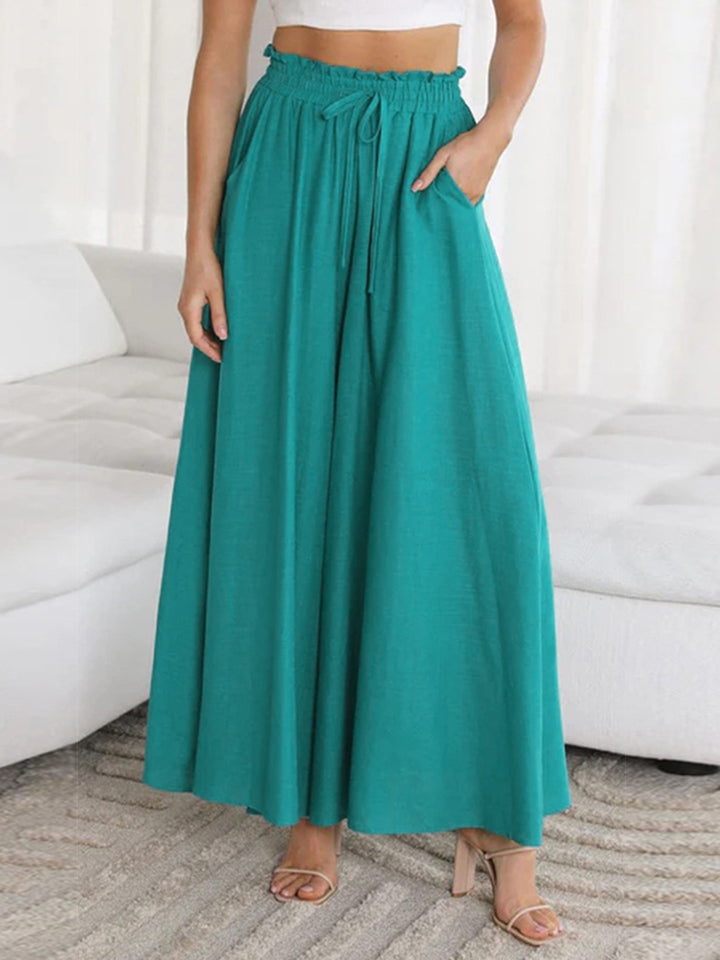 Teal gathered waist palazzo pants with drawstring and pockets, made of 100% polyurethane.