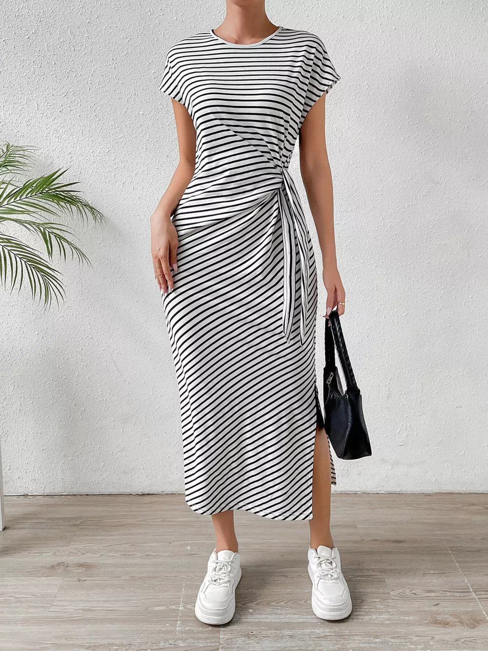 Black and white striped midi dress with tie-side detail and thigh slit.