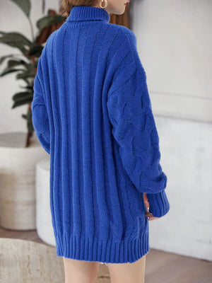 Royal blue cable knit turtleneck mini dress with ribbed texture and cable sleeves.