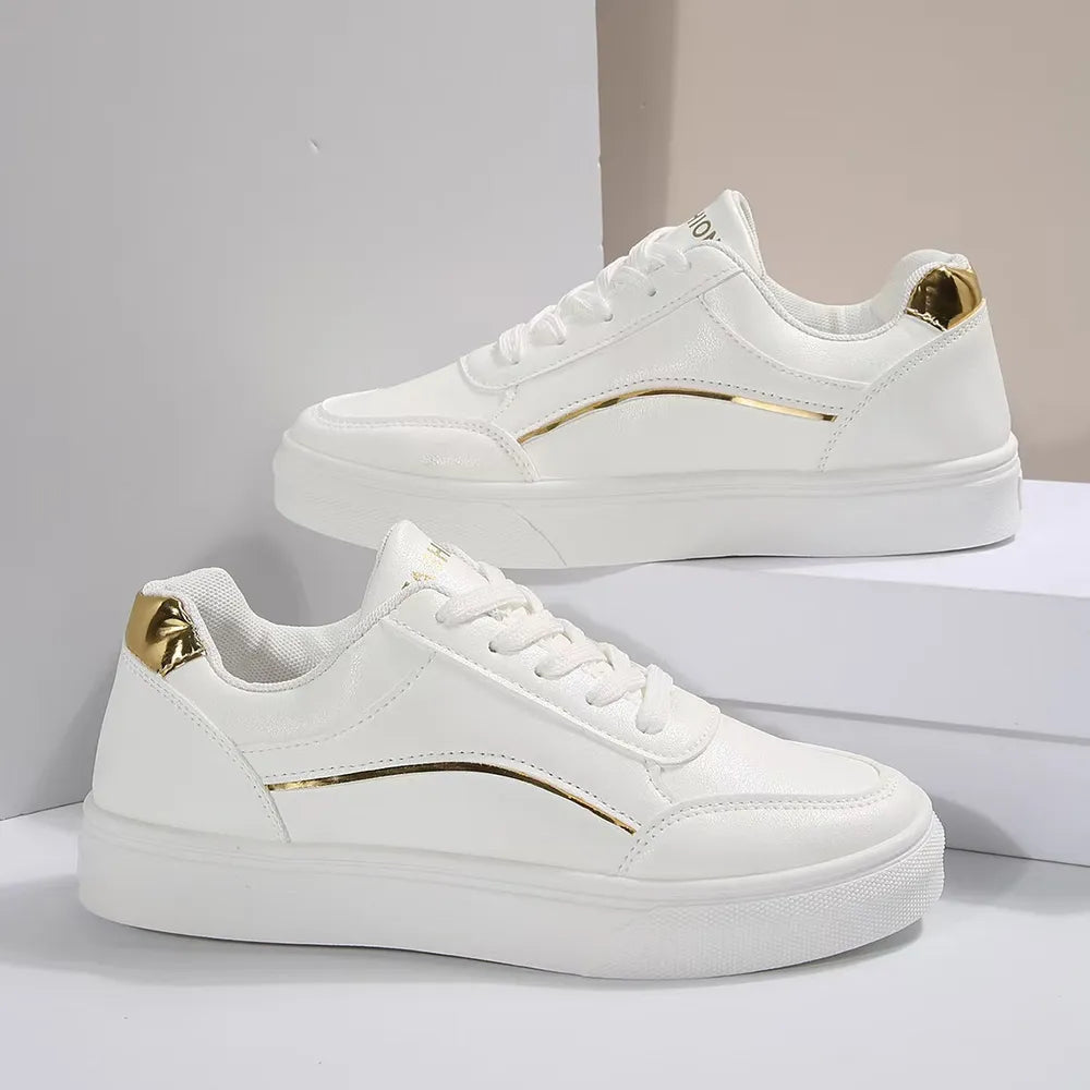 White sneakers with gold metallic trim and heel detail