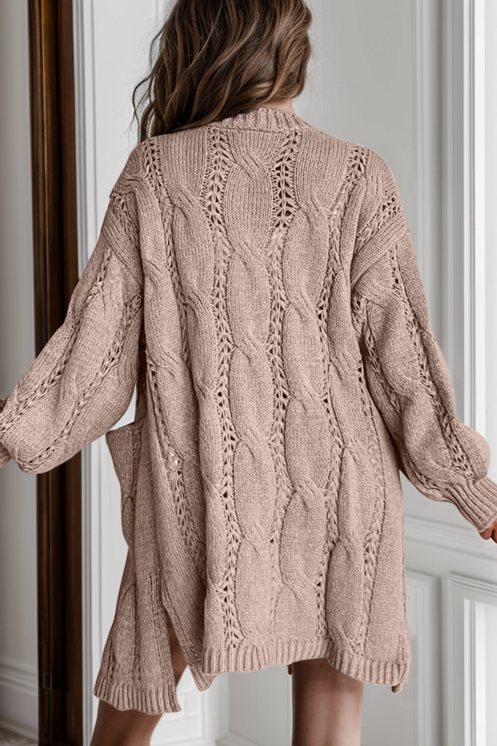 Camel cable knit open-front cardigan with pockets and openwork details.