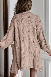 Camel cable knit open-front cardigan with pockets and openwork details.