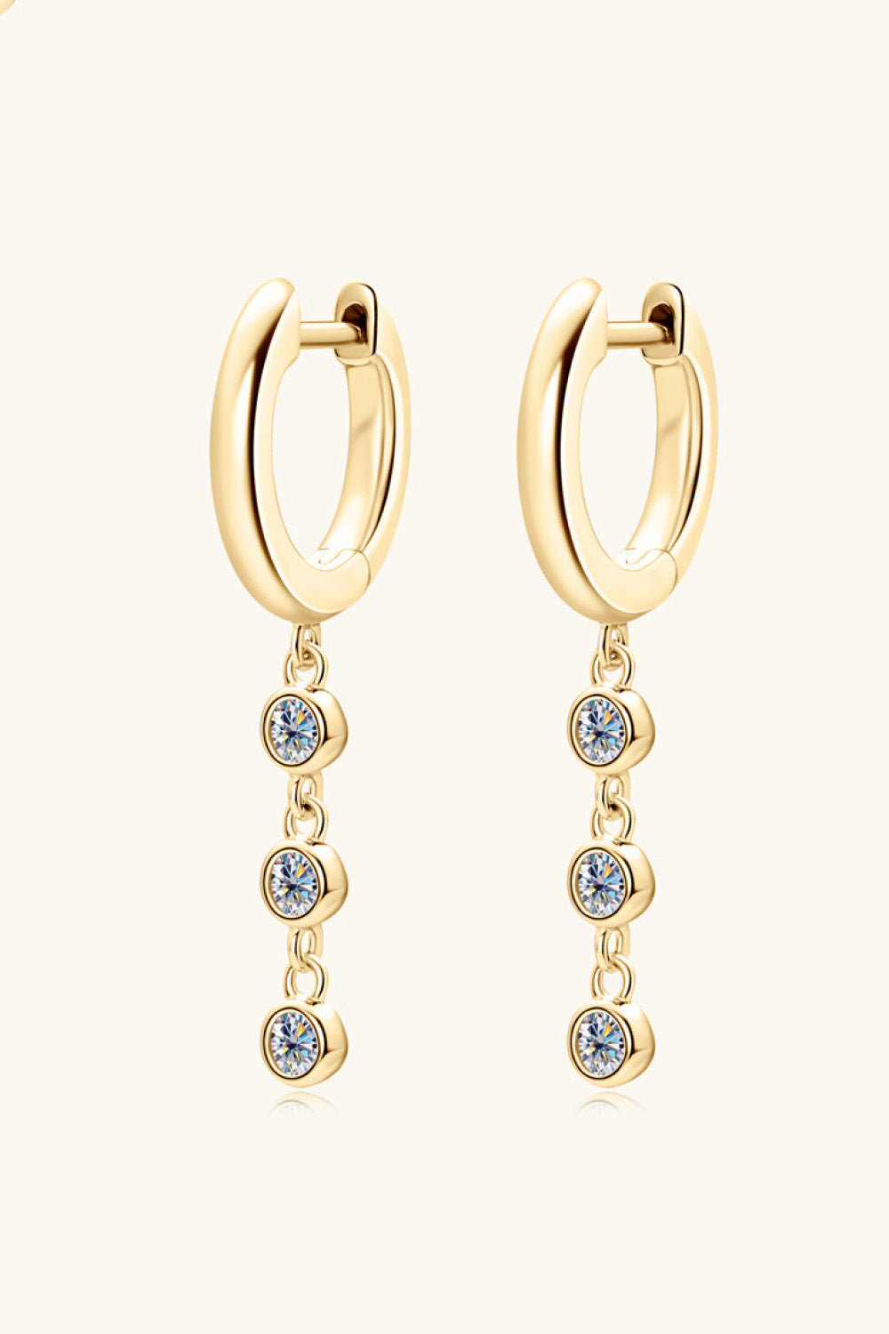 Gold dangling gemstone sterling hoop earrings with three clear cubic zirconia stones.