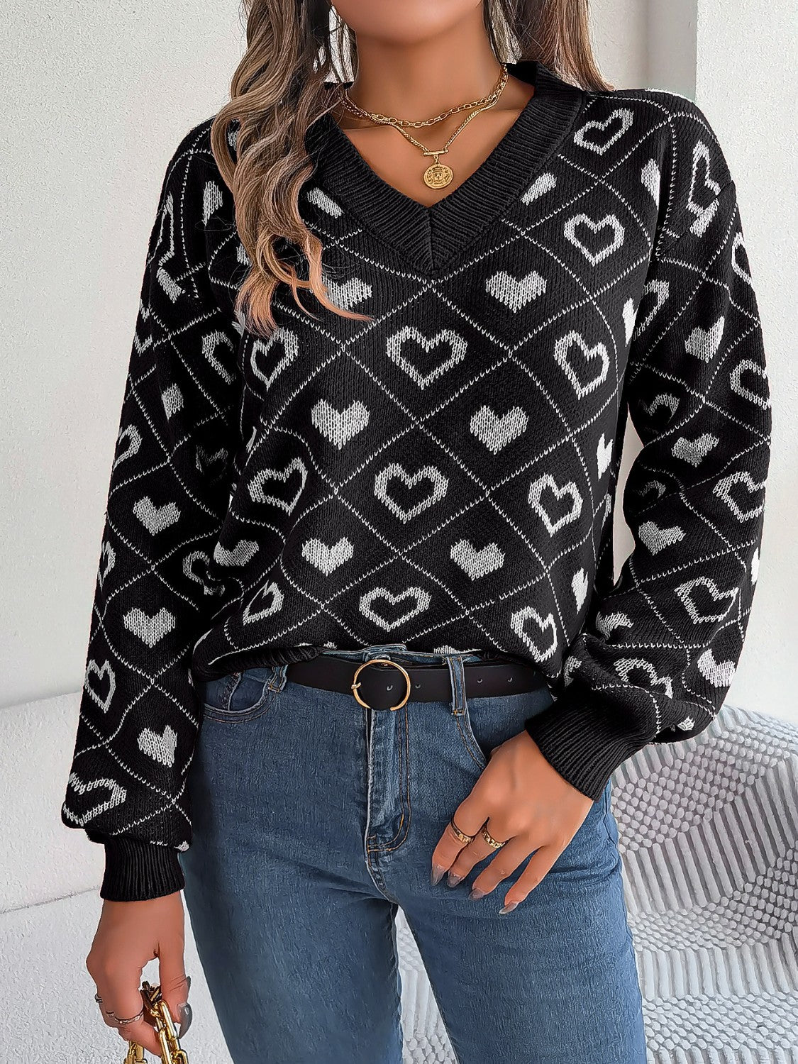 Black acrylic v-neck sweater with white heart jacquard pattern and long sleeves