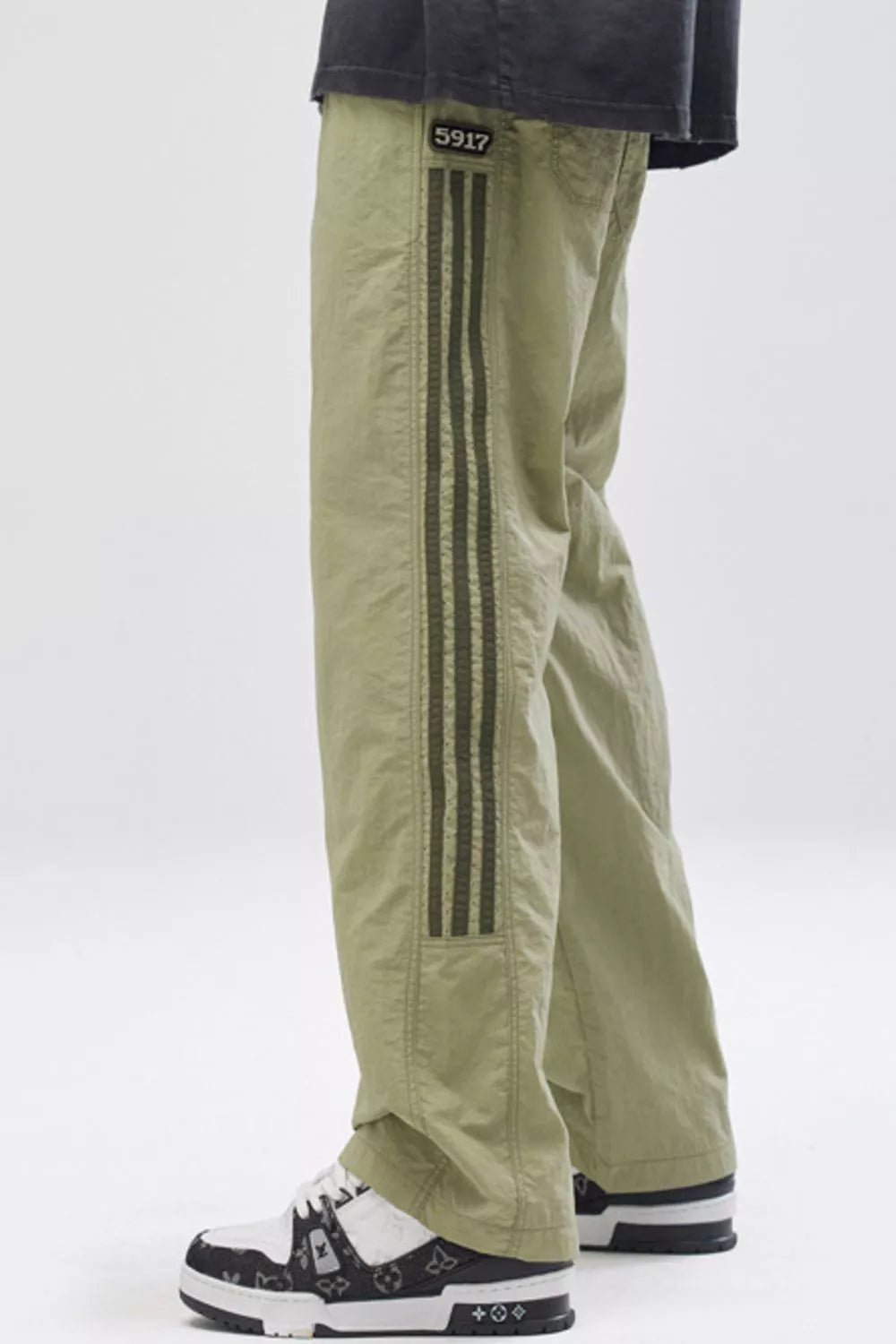 Light green casual drawstring sweatpants with dark green side stripes and a "5917" patch.