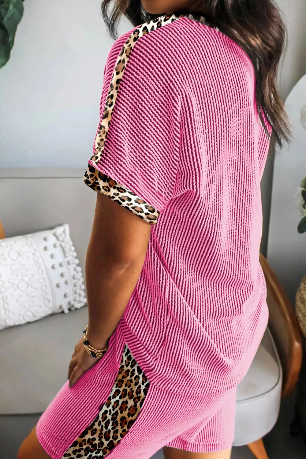 Pink ribbed pajama set with leopard trim on sleeves and sides.