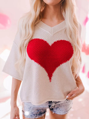 Beige V-neck knit sweater with large red heart pattern, short sleeves, and casual fit.