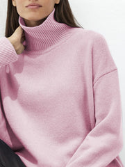 Relaxed fit ribbed turtleneck sweater in blush pink acrylic with a relaxed cut.