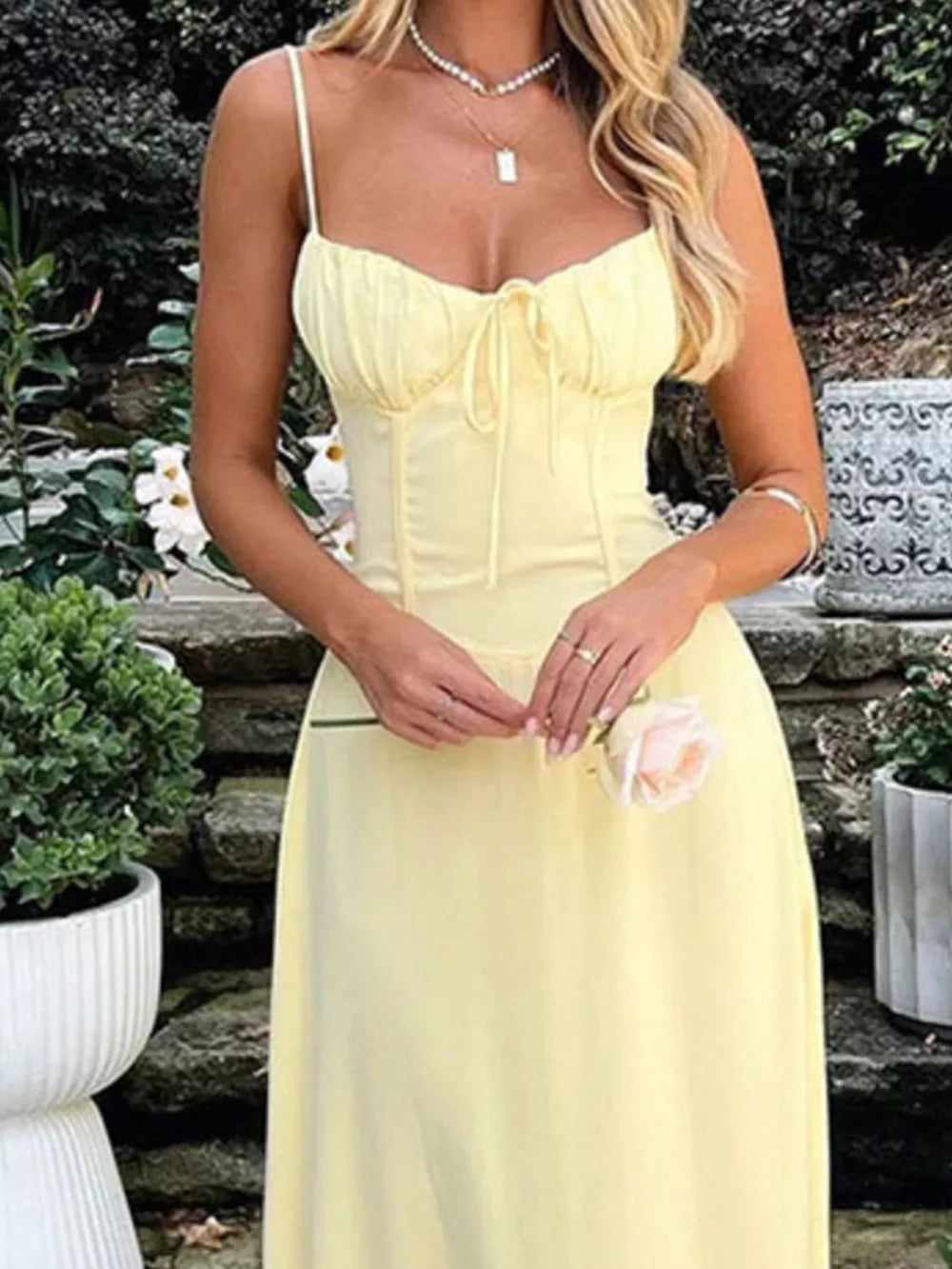 Pastel yellow tie-front maxi dress with spaghetti straps and a cinched waist detail.