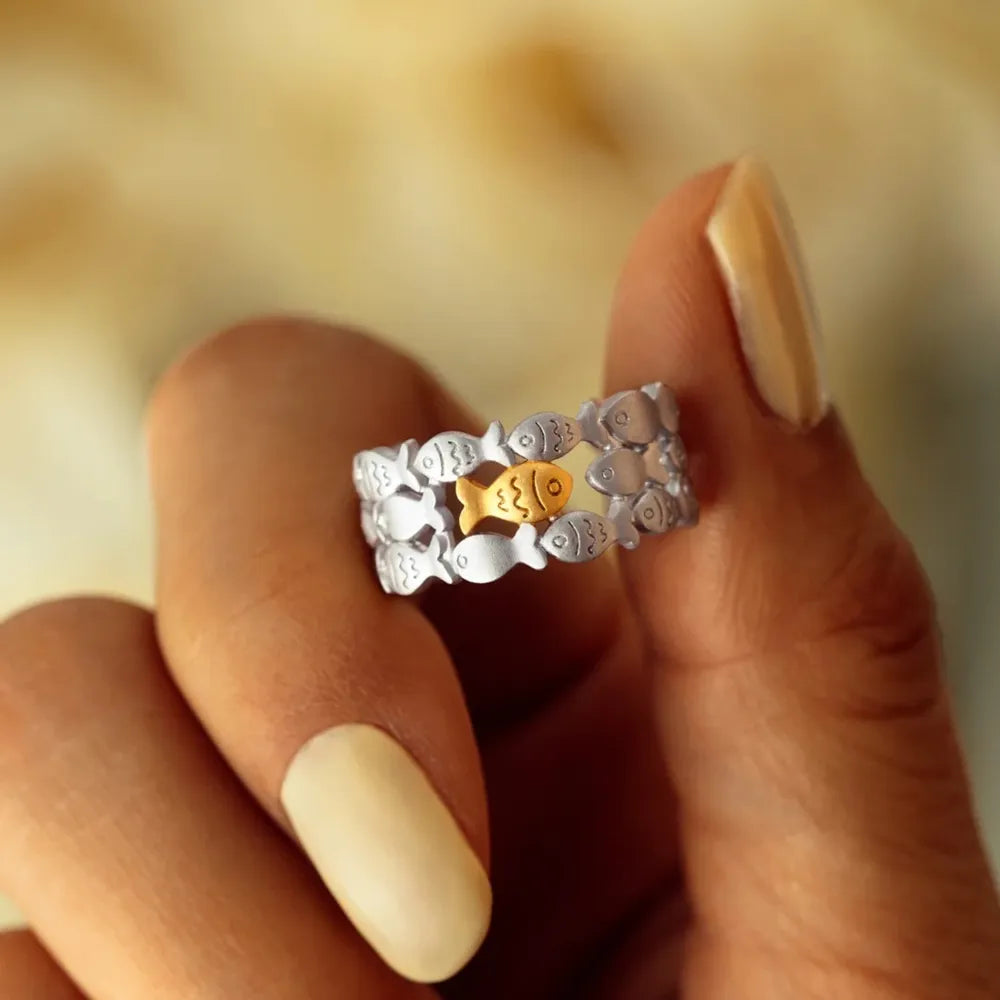 Adjustable ring with a school of silver fish and one gold fish in the center.