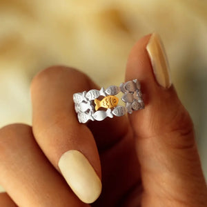 Adjustable ring with a school of silver fish and one gold fish in the center.