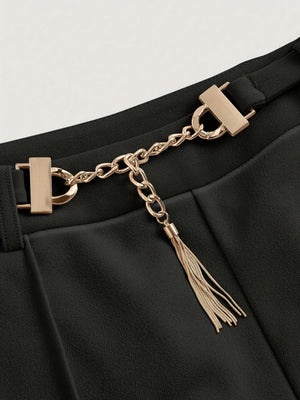 Black flared leg trousers with gold chain detail and tassel accent.