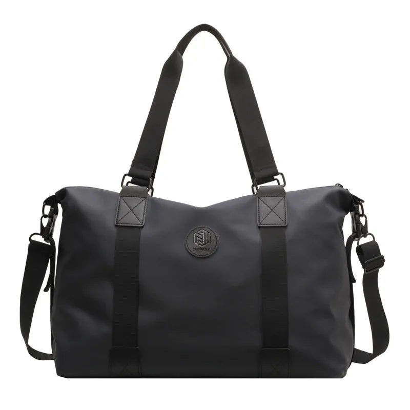 Black canvas duffel bag with dual handles, adjustable shoulder strap, and embossed logo.