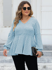 Pastel blue ribbed peplum knit top with blouson sleeves and V-neck.