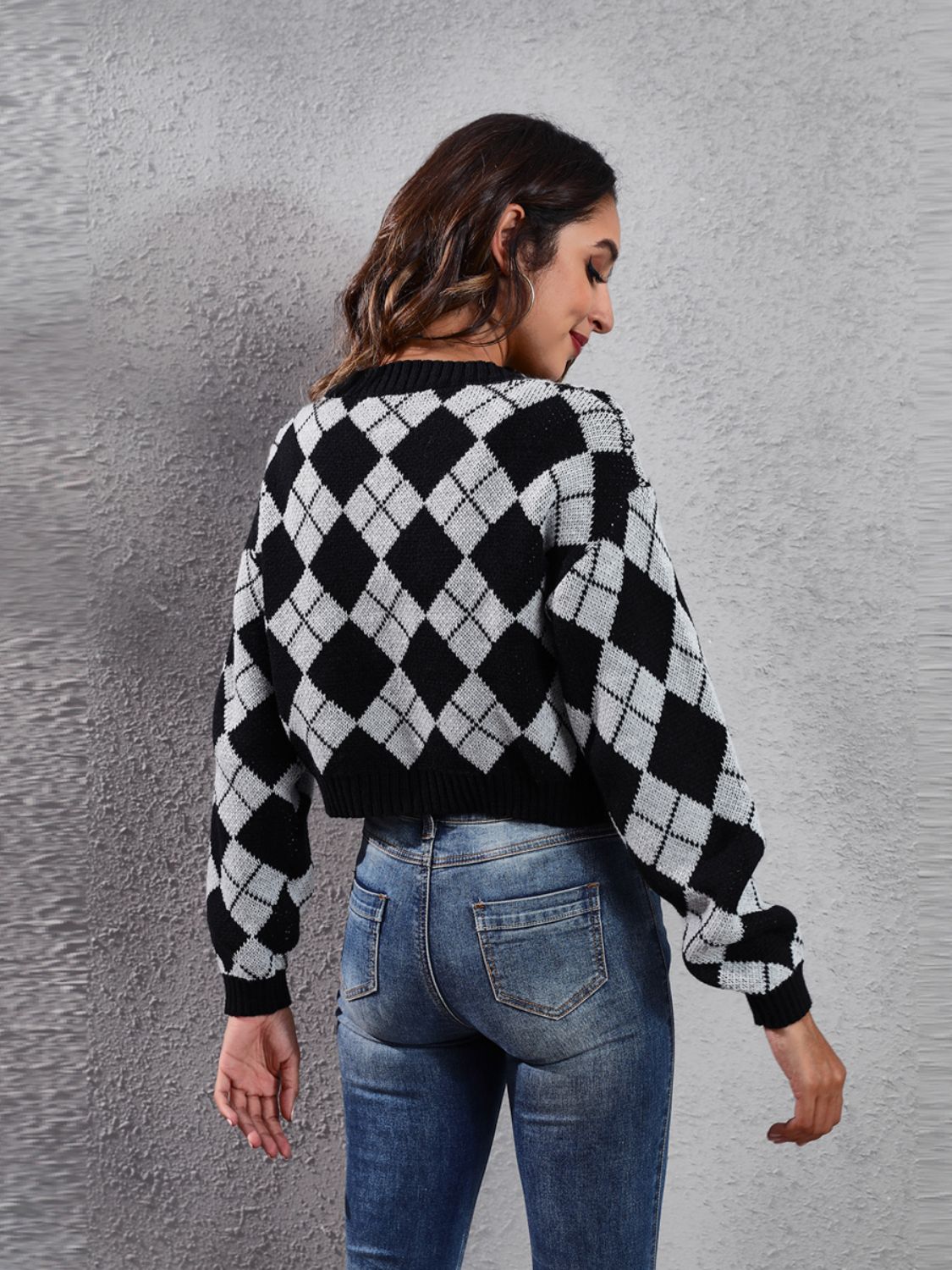 Argyle cropped cardigan in black and white acrylic with a crew neck and long sleeves.