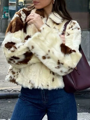 Cropped faux fur zip up jacket in beige with brown patches, featuring a collar and full zip closure.