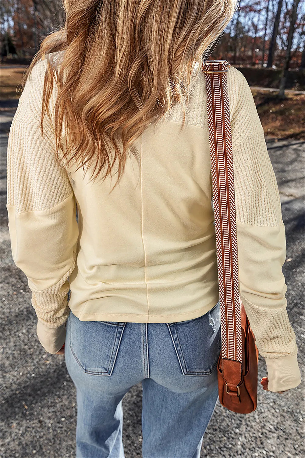 Beige waffle knit colorblock sweatshirt with textured sleeves and a smooth body.