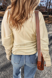 Beige waffle knit colorblock sweatshirt with textured sleeves and a smooth body.