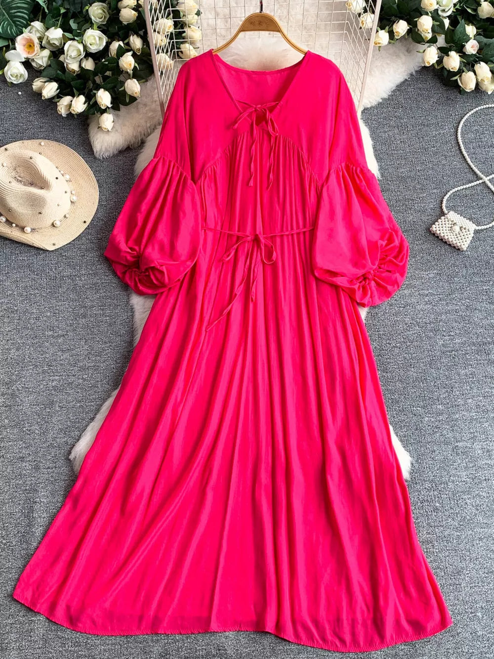 Fuchsia pink polyester maxi dress with balloon sleeves, tie neckline, and cinched waist.