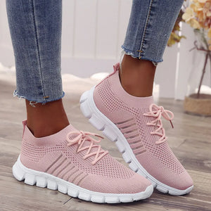 Pink knit runner sneakers with ribbed detail and white soles.