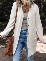 White fuzzy button-front cardigan with pockets and gold buttons, styled with jeans.