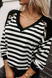 Black and white striped blouse with V-neck and decorative gold buttons on shoulders.