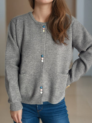 Gray ribbed knit button-up cardigan with pastel colored buttons and pockets.