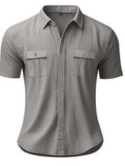 Grey short sleeve button-down shirt with two chest pockets and subtle plaid texture.