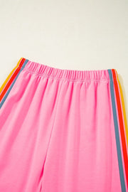 Pink track pants with rainbow stripe detail on side