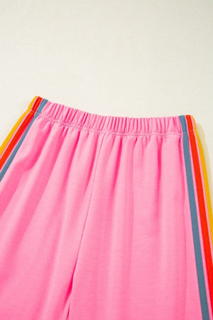 Pink track pants with rainbow stripe detail on side