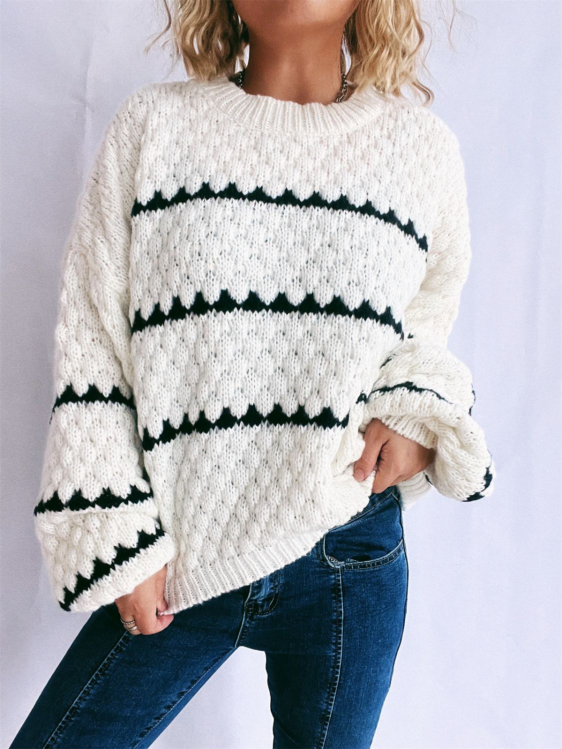 White acrylic knit jumper with black chevron stripe pattern and textured detail.