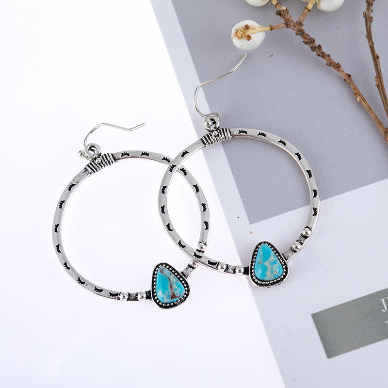 Southwestern stone hoop earrings in silver with turquoise inlay and textured details.