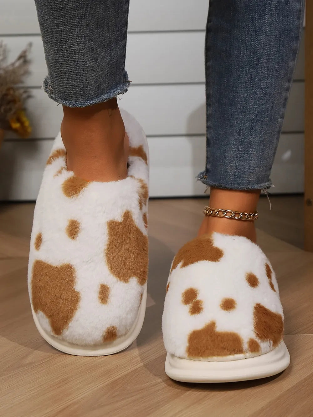 Cow print faux fur house slides in white and brown, with a plush texture.