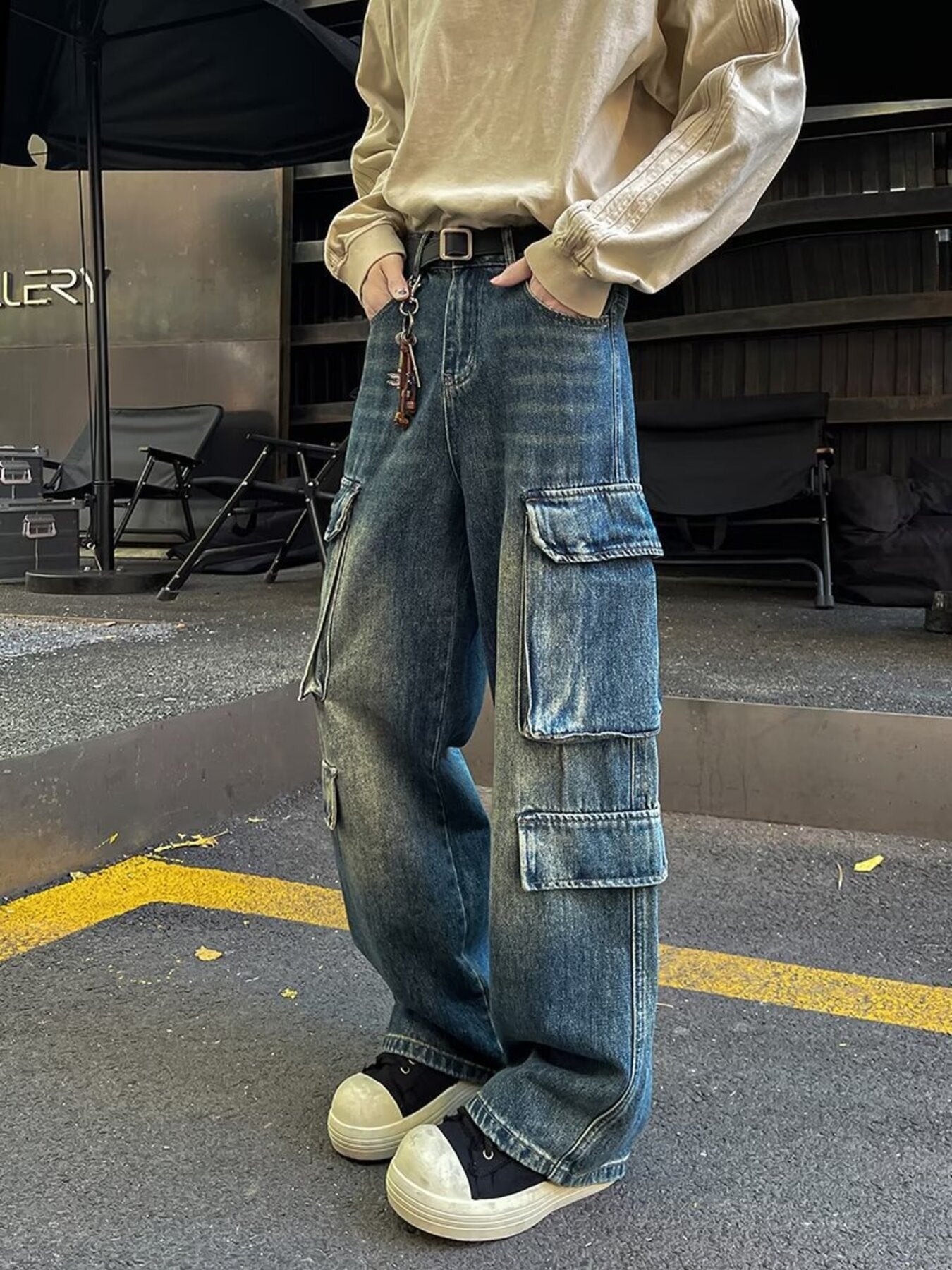 Men's vintage wash blue wide-leg cargo jeans with multiple pockets and a baggy fit.