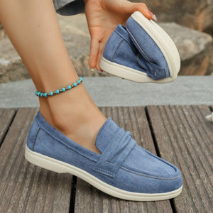Blue round toe slip-on loafers with ruched detail and white sole.