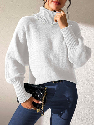 White knit sweater with pearl-embellished turtleneck and dolman sleeves.