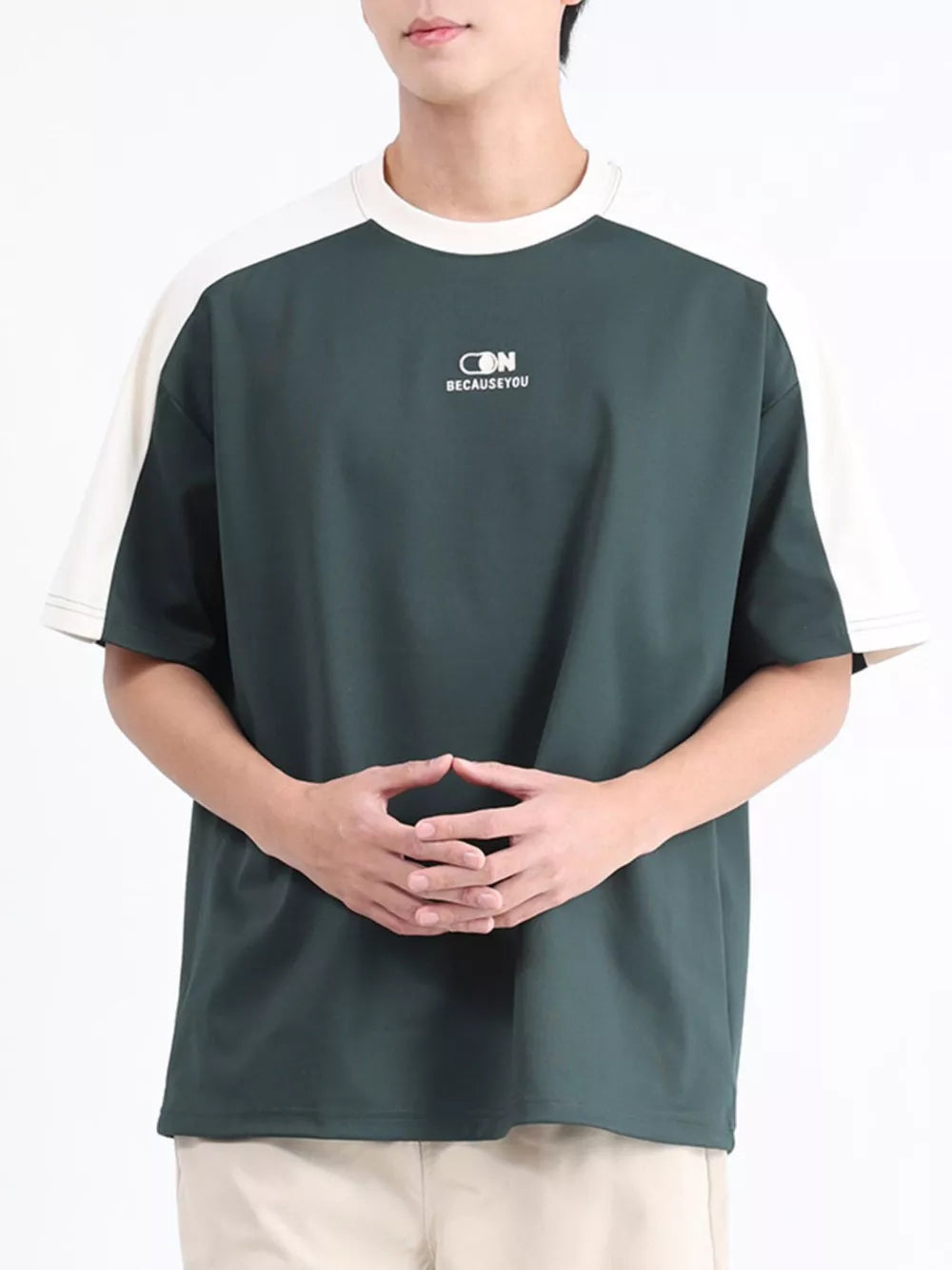 Men's dark green t-shirt with white contrast sleeves and subtle logo detail.
