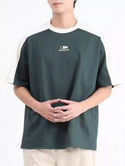 Men's dark green t-shirt with white contrast sleeves and subtle logo detail.