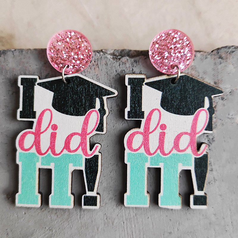 Graduation drop earrings with pink glitter tops and "I did it" text.