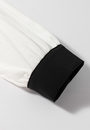 White textured blouse sleeve with black trim detail