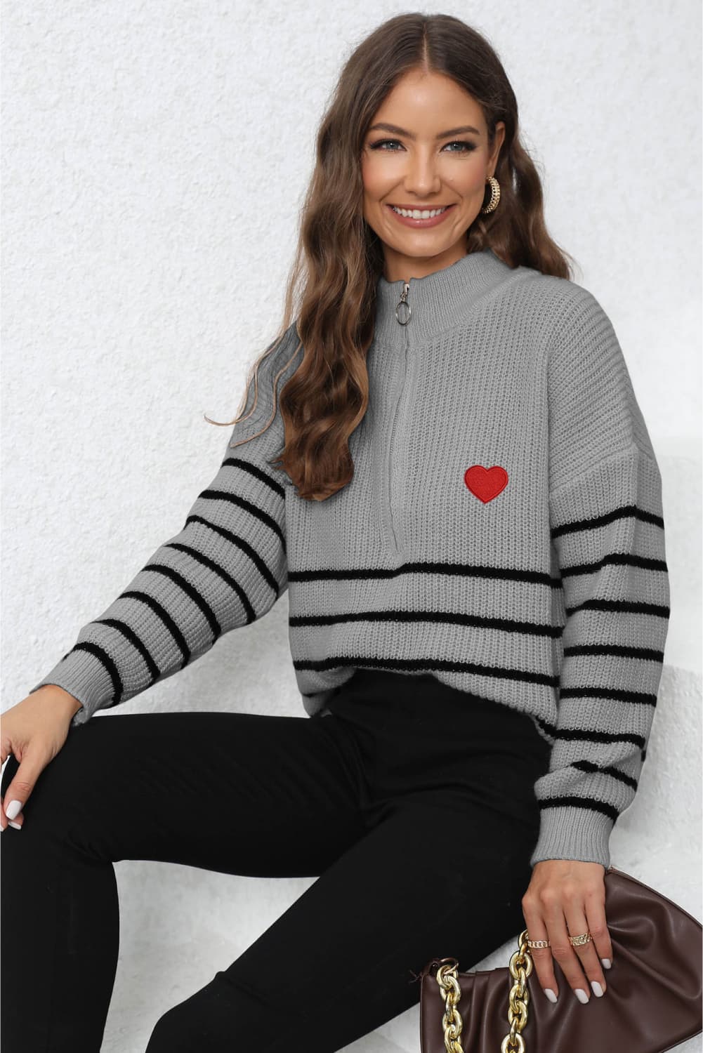 Grey knit sweater with black stripes, red heart patch, and quarter zip neckline.