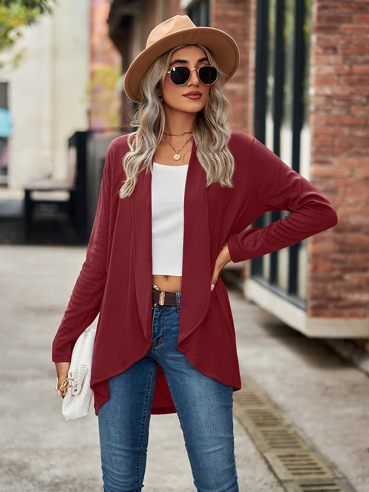 Draped cascade cardigan in wine with open front and long sleeves, styled with jeans.