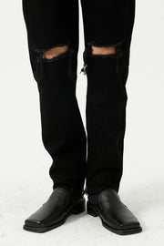Black denim jeans with distressed knees and a modern straight leg cut.