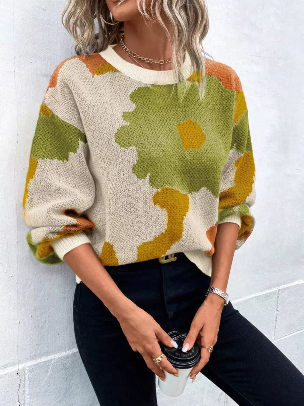 Abstract floral knit sweater with round neck in green, yellow, and orange on cream.