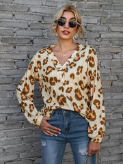 Leopard print henley blouse in brown with blouson sleeves and button detail.