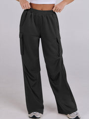 Black sweatpants with cargo pockets and a wide leg, featuring a comfortable elastic waistband.