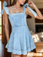 Light blue denim fit-and-flare dress with bow straps and a square neckline.